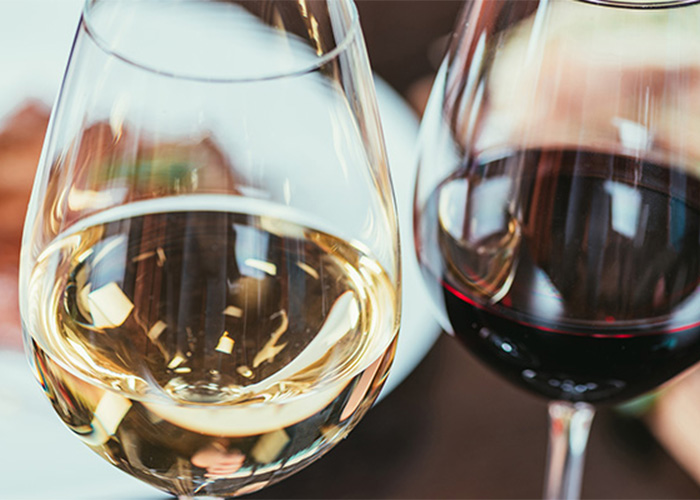 Close-up of white and red wine glasses on a table from Rendezvous Restaurant Menu.